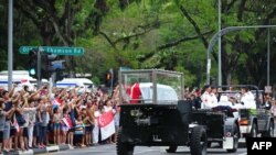 Members of the public react as the ceremonial gun carriage bearing Singapore's late former prime minister Lee Kuan Yew passes by during his funeral procession in Singapore on March 29, 2015. Tens of thousands of mourners braved torrential rain, howitzers 