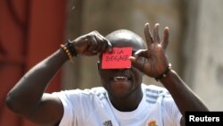 A Congolese opposition party supporter gestures as he displays a red card against President Joseph Kabila in Kinshasa, Democratic Republic of Congo December 19, 2016.