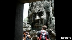 A tourist poses for photographs in the Bayon Temple in the northern province of Siem Reap, file photo. 