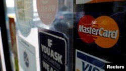 FILE - A sticker shows that a store accepts MasterCard in Harvard Square in Cambridge, Massachusetts.