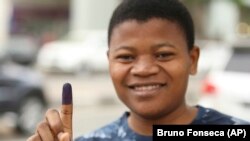 Um eleitor mostra o dedo pintado com a tinta indelével depois de votar em Luanda, Angola. 23 de Agosto 2013