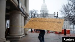 Lokalne prodavnice i firme u blizini državnog kapitola daskama zaštićuju svoje izloge pre najavljenih protesta u Lensingu u Mičigenu, 15. januara 2020.