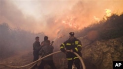 Firefighters try to extinguish the flames in Tirat Hacarmel, northern Israel, 03 Dec 2010