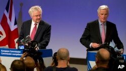 FILE - EU Chief Brexit Negotiator Michel Barnier, right, and British Secretary of State for Exiting the EU David Davis arrive for a media conference at EU headquarters in Brussels, June 19, 2017.