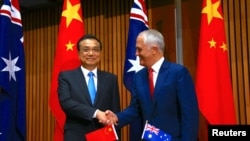Perdana Menteri China Li Keqiang (kiri) dan Perdana Menteri Australia Malcolm Turnbull berjabat tangan sebelum penandatanganan kesepakatan di Gedung Parlemen di Canberra, Australia, 24 Maret 2017. (REUTERS/David Gray).