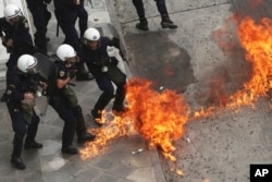 Riot police officers try to avoid a petrol bomb thrown by protester during a nationwide general strike demonstration. in Athens, May 17, 2017.