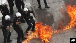 Riot police officers try to avoid a petrol bomb thrown by protester during a nationwide general strike demonstration. in Athens, May 17, 2017. 