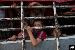 Children travel on a cattle truck, as a thousands-strong caravan of Central American migrants slowly makes its way toward the U.S. border, between Pijijiapan and Arriaga, Mexico, Oct. 26, 2018.