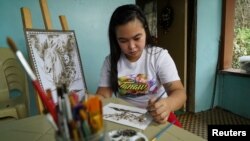 Filipina artist Janina Sanico uses volcanic ash she found in her yard to paint images of Taal volcano inside her home in Tanauan, Batangas Province, Philippines, January 24, 2020. (REUTERS/Joseph Campbell)