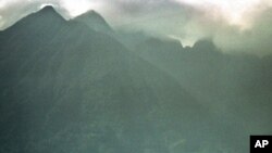 FILE - An afternoon shower rolls in over the volcanic mountains of Virunga National Park, home to a famous gorilla reserve, Sept. 23, 1997. The Democratic Republic of Congo is planning to sell land blocks that extend into the park to use for oil and gas exploration.