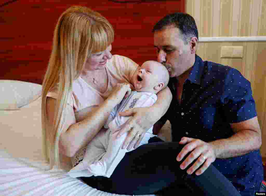 Jose Perez and Flavia Lavorino from Buenos Aires react during the first meeting with their son Manuel, who was born to a surrogate mother in a Ukrainian BioTexCom clinic in Kyiv, Ukraine.