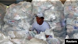 A worker organizes humanitarian aid for Venezuela at a warehouse near the Tienditas cross-border bridge between Colombia and Venezuela in Cucuta, Colombia, Feb. 8, 2019.