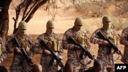 FILE - Still image from video uploaded to social media purportedly shows me kneeling on the ground in front of masked Islamic State militants before a choreographed execution in a desert area at an undisclosed location in Libya, March 2015.