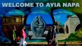 Tourists walk at southeast resort of Ayia Napa, in the eastern Mediterranean island of Cyprus, Saturday, May 22, 2021. (AP Photo/Petros Karadjias)