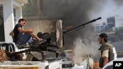 Libyan rebel fighters prepare to shoot towards pro-Gadhafi forces during fighting in downtown Tripoli, LIbya, Monday, Aug. 22, 2011