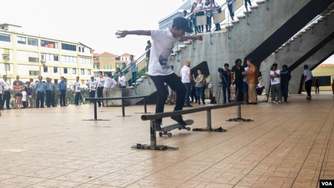 យុវជនបង្ហាញសមត្ថភាពលេងកីឡាក្តាររំអិលរបស់ខ្លួន នៅពហុកីឡាដ្ឋានជាតិអូឡាំពិច កាលពីថ្ងៃទី៥ ខែសីហា ឆ្នាំ២០១៧។ (រ៉ាវី សុភារ័ត្ន/VOA)