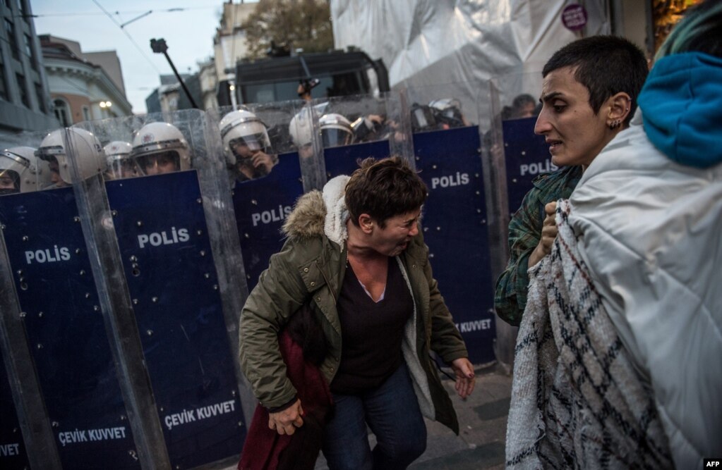 세계 여성 폭력 근절을 위한 유엔의 날을 맞아 터키 이스탄불에서 여성단체회원 등 시위대가 구호를 외치며 시내를 행진한 가운데, 한 여성이 터키 경찰이 발사한 최루가스를 맞고 얼굴을 찡그리고 있다.