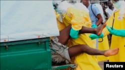 Health workers push an Ebola patient who escaped from quarantine in Monrovia's Elwa hospital into an ambulance in the centre of Paynesville, Sept. 1, 2014.