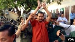 Opposition party member Meach Sovannara is escorted by police following a rejection by the courts he be released on bail, December 12, 2014.