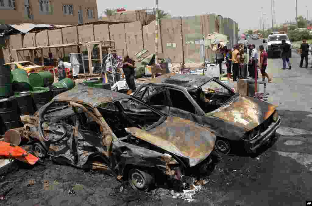 People inspect the aftermath of a car bomb attack in Sadr City, Baghdad, Iraq, July 23, 2012.