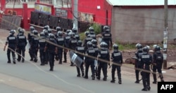 FILE - Cameroon police officials walk with riot shields on a street in the administrative quarter of Buea some 60 kms west of Douala, Oct. 1, 2017.