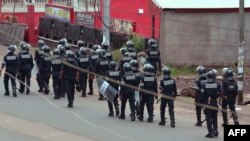 Cameroon police officials walk with riot shields on a street in the administrative quarter of Buea some 60kms west of Douala, Oct. 1, 2017.