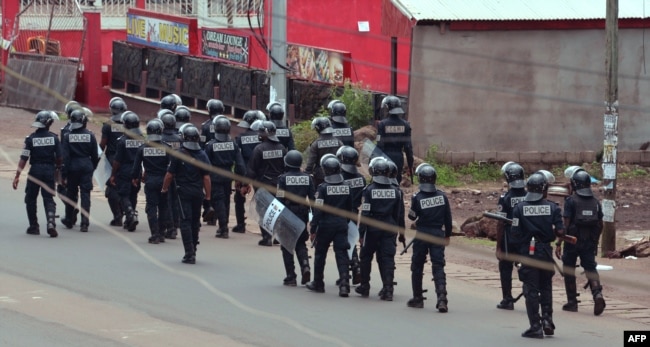 FILE - Cameroon police officials walk with riot shields on a street in the administrative quarter of Buea some 60kms west of Douala, Oct. 1, 2017.