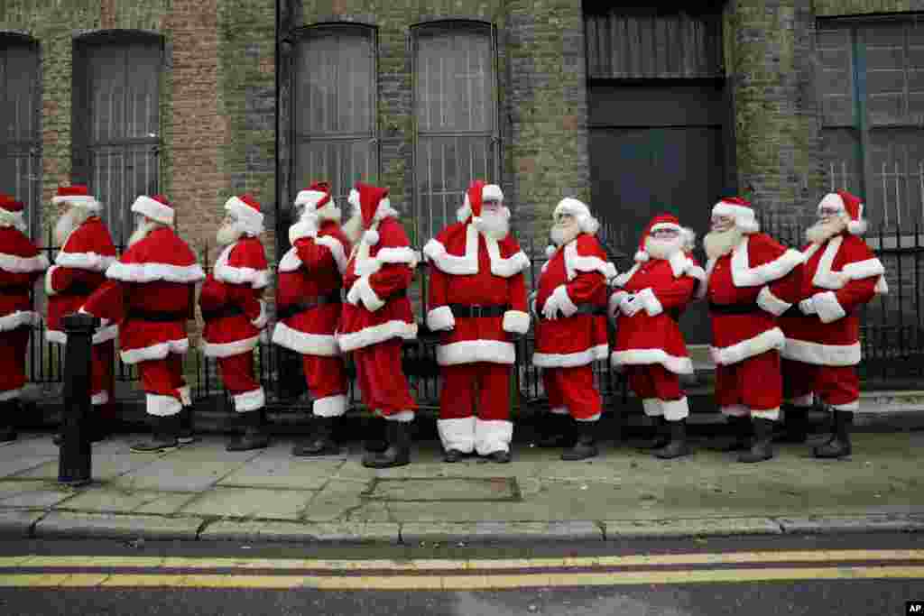 Performers dressed as Santa Claus stand in a line outside the Ragged School Museum in east London. The Ministry of Fun Santa School is Britain&#39;s only genuine training school for professional Santas, preparing them to help out in grottos, department stores, attractions and events over the Christmas period.