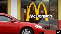 FILE - A car is seen moving through a McDonald's drive-through window line, in Springfield, Illilois.