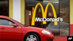 FILE - A car is seen moving through a McDonald's drive-through window line, in Springfield, Illilois.