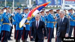 Russian President Vladimir Putin (L) and Serbian President Tomislav Nikolic walk in front of a honor guard in front of the Serbia Palace building in Belgrade Oct. 16, 2014.