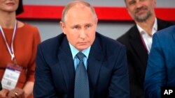 俄罗斯总统普京2019年5月16日在莫斯科出席“全俄人民阵线”的会议时听取问题。