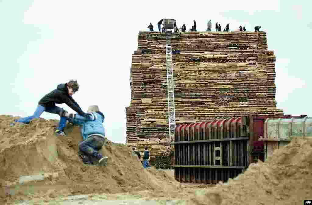 People stack wooden pallets prior to the traditional bonfire of New Year's Eve, in Scheveningen, the Netherlands.