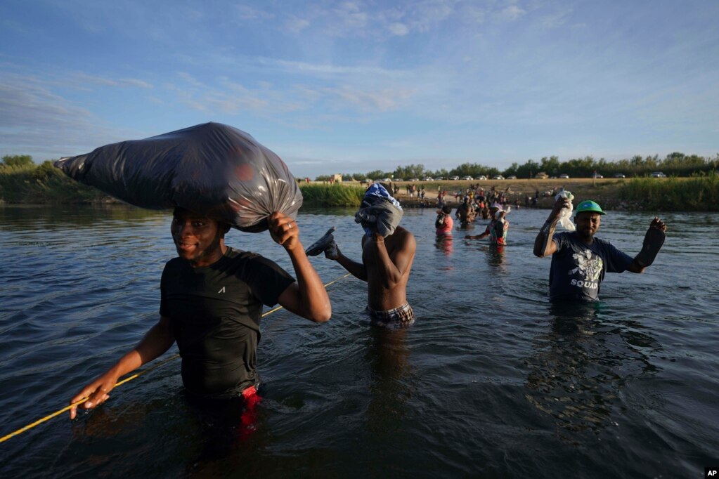 包括很多海地人在内的移民离开德克萨斯州的德尔里奥，淌水越过格兰德河，返回墨西哥一侧，有些人是为了躲避美国遣返，有些人则是为了补充物资。(2021年9月22日)(photo:VOA)