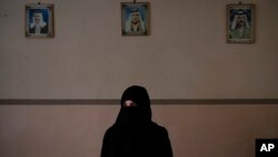FILE - Khadija Abd poses for a portrait in her family's house in Mosul, Iraq, Apr. 14, 2019. On a chilly January evening, the Abd family had just finished supper at their farm when the two men with guns burst into the room.