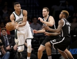 Giannis Antetokounmpo dari Milwaukee Bucks, kiri, mengoper bek Brooklyn Nets pada paruh kedua pertandingan bola basket NBA di Barclays Center, Minggu, 13 Maret 2016 di New York. (Foto: AP)