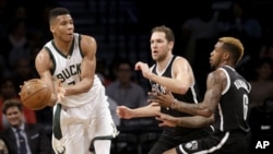  Milwaukee Bucks' Giannis Antetokounmpo, à gauche, essaie de passer les défenseurs de Brooklyn Nets lors d'un match de NBA, New York le 13 mars 2016 (AP Photo/Seth...