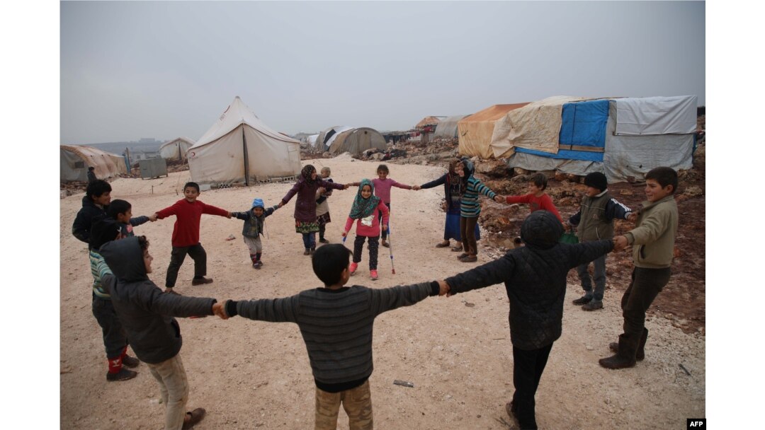Maya Merhi stands in the middle as her friends surround her in the Internally Displaced Persons camp of Serjilla in northwestern Syria next to Bab al-Hawa border crossing with Turkey, on Dec. 9, 2018. Eight-year-old Maya,was born without legs.