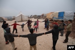 Maya Merhi stands in the middle as her friends surround her in the Internally Displaced Persons camp of Serjilla in northwestern Syria next to Bab al-Hawa border crossing with Turkey, on Dec. 9, 2018. Eight-year-old Maya,was born without legs.