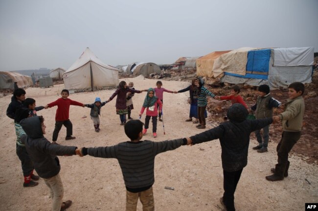 Maya Merhi stands in the middle as her friends surround her in the Internally Displaced Persons camp of Serjilla in northwestern Syria next to Bab al-Hawa border crossing with Turkey, on Dec. 9, 2018. Eight-year-old Maya,was born without legs.