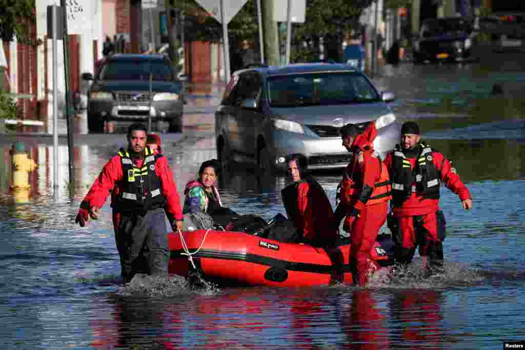 First responders pull local residents in a boat as they rescue people trapped by floodwaters after the remnants of Tropical Storm Ida brought drenching rain, flash floods and tornadoes to parts of the northeast in Mamaroneck, New York.