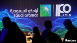 FILE - A sign referring to Saudi Aramco's initial public offering is seen during a news conference by the state oil company at the Plaza Conference Center in Dhahran, Saudi Arabia, Nov. 3, 2019.