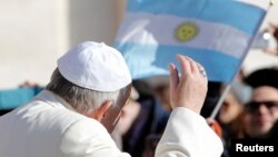 El papa Francisco saluda en dirección de una bandera argentina a su llegada a la audiencia semanal en la Plaza de San Pedro, en el Vaticano.