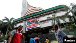 People look at a screen displaying India's Finance Minister Arun Jaitley presenting the budget, on the facade of the Bombay Stock Exchange (BSE) building in Mumbai, Feb. 28, 2015. 