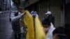 Workers wearing face masks repair barriers built up to block buildings from a street in Wuhan, Hubei province, the epicenter of China's coronavirus disease (COVID-19) outbreak.