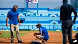 Murray Cook, left, and Phil Bradley, right, from the Major League Baseball Players Association talk to a worker during the refurbishing of the Latinoamericano stadium, March 16, 2016. The Tampa Bay Rays will play the Cuban national team March 22 in Havana.