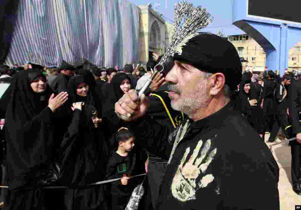 A Shi'ite worshipper beats himself with chains as a sign of grief for Imam Hussein during Muharram between the holy shrines of Imam Hussein and Imam Abbas in Karbala, Iraq, Nov. 13, 2013. 