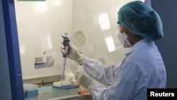 FILE - A scientist tests a sample from someone who recently returned from South Korea and is suspected of MERS infection, inside a lab at the National Institute of Health Department of Medical Sciences on the outskirts of Bangkok, Thailand, June 18, 2015. 