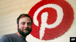 FILE - Pinterest co-founder and chief product officer, poses for a photo beside a wall of pegs symbolizing the company logo at Pinterest headquarters in San Francisco, Oct. 11, 2018. 