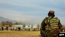 FILE - A Taliban security personnel keeps watch ahead of the court flogging of women and men at a football stadium in Parwan province, Dec. 8, 2022. 